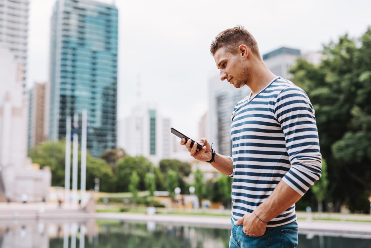 Young expat man in Australia using his phone to check his bank account