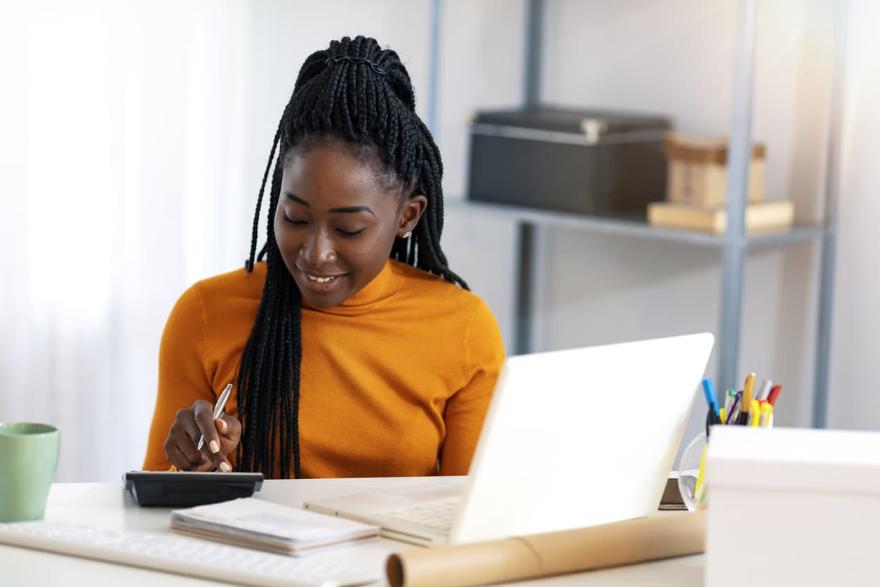 Young woman calculating her payments in front of a computer